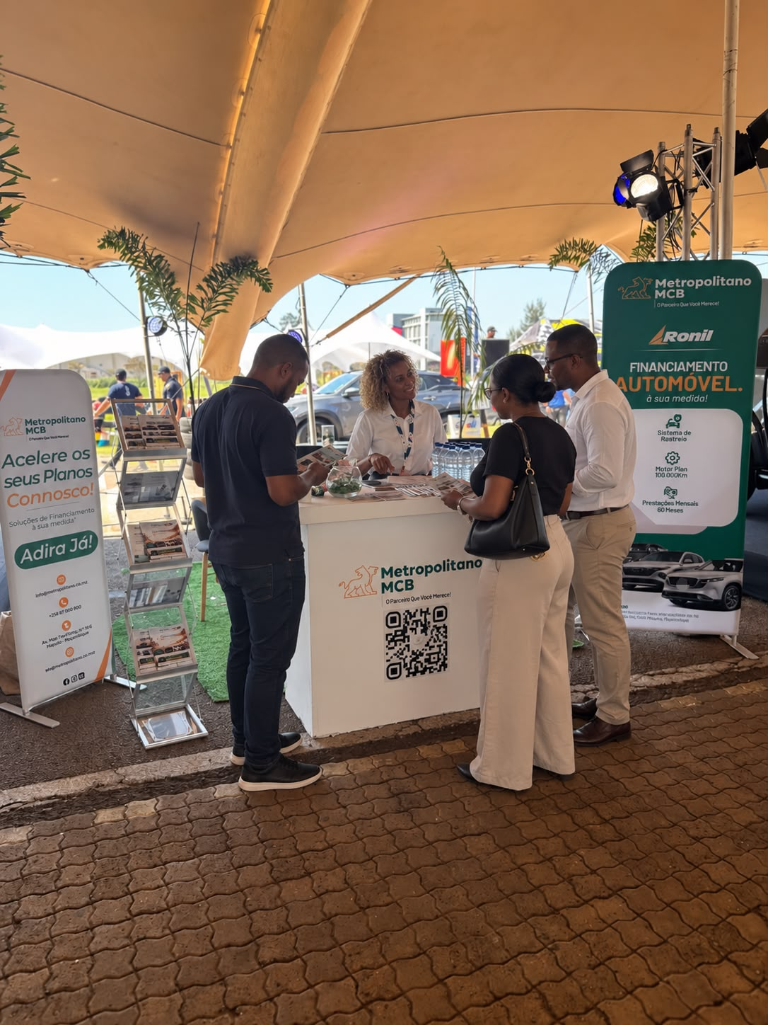 Colaboradora do Metropolitano MCB ao balcão do stand, a atender visitantes na comemoração do 80.º aniversário da Ronil